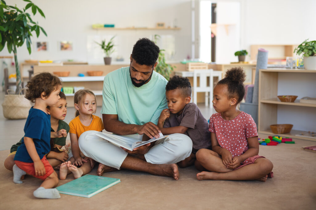 Teacher reading to several small children.