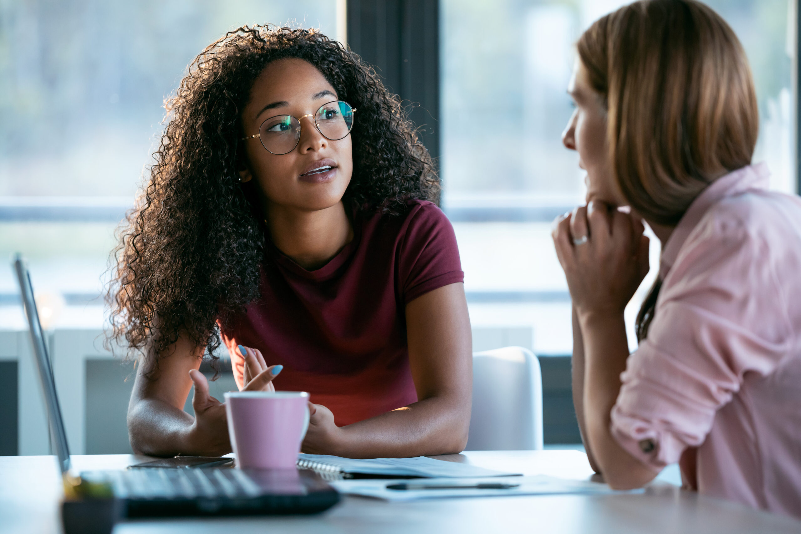 Two women at a table with a laptop.