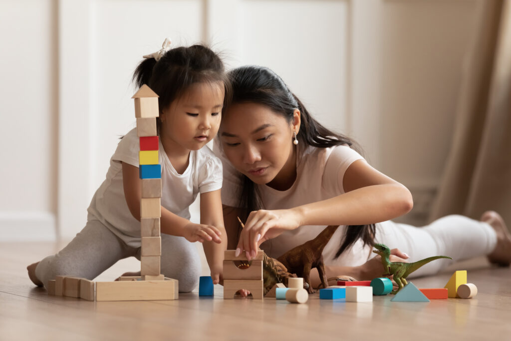 Teacher playing with small child.