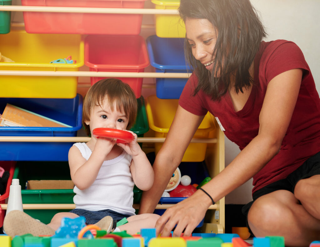 Teacher playing with small child.