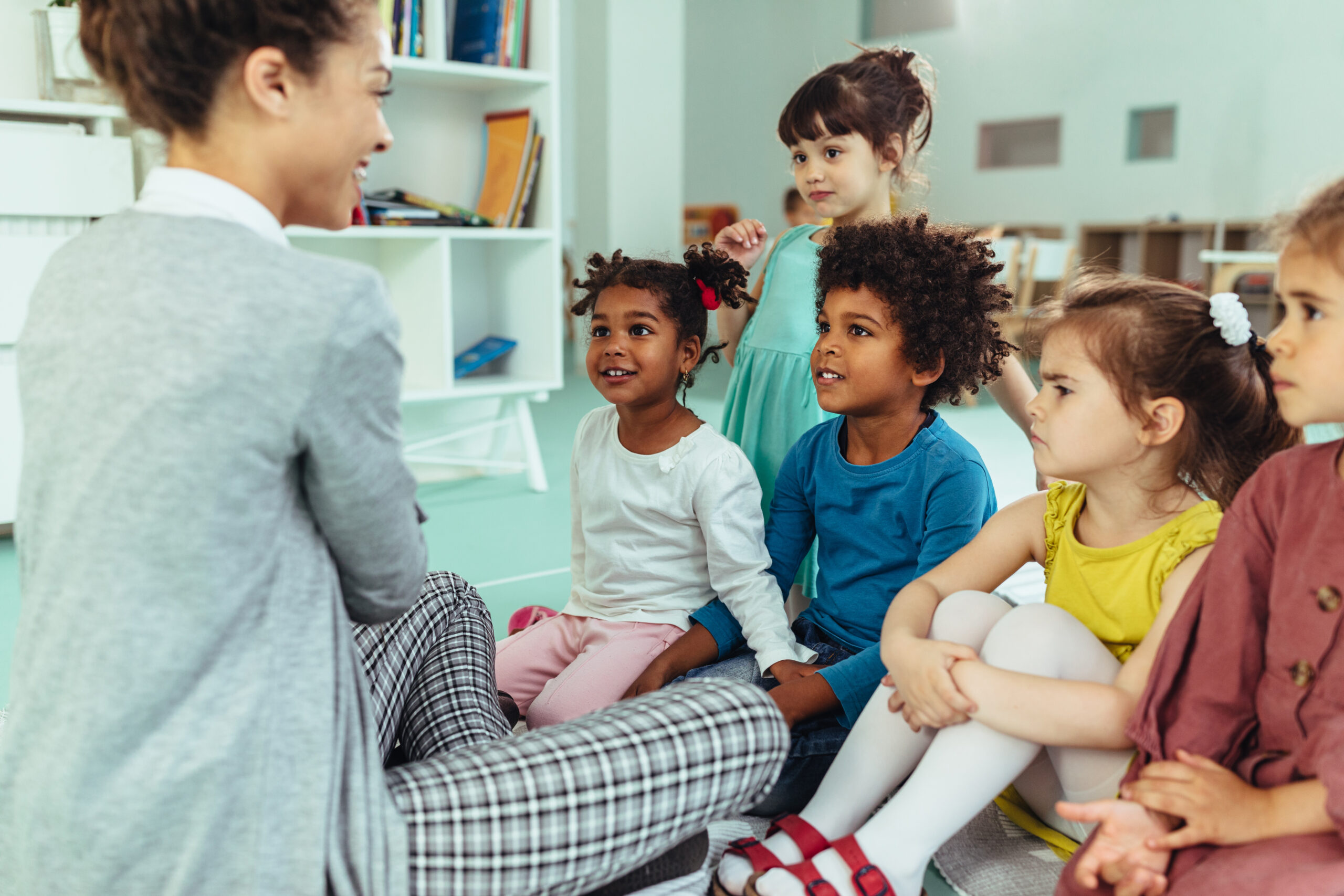 Teacher reading to a group of children.