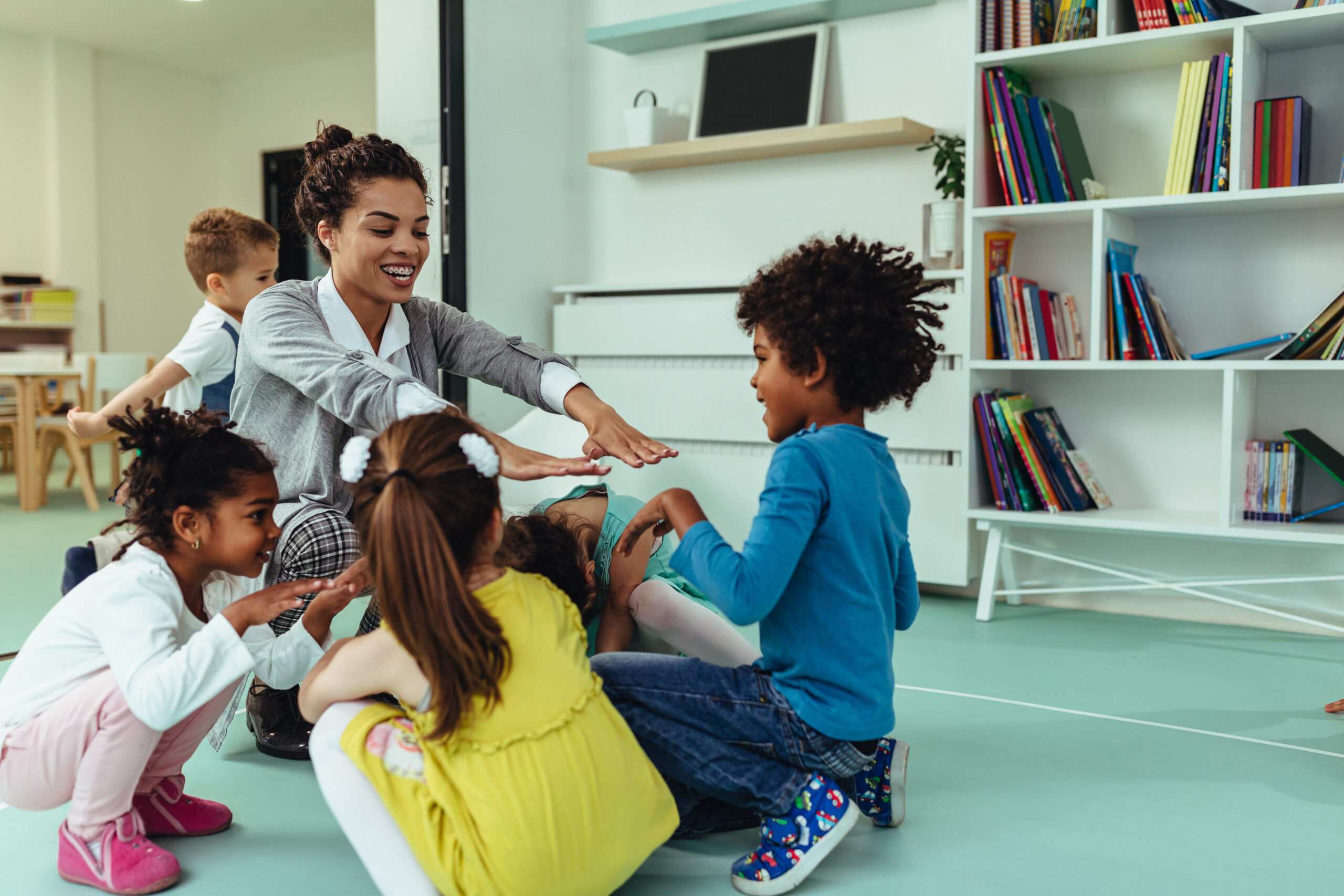 Teacher playing with young children.