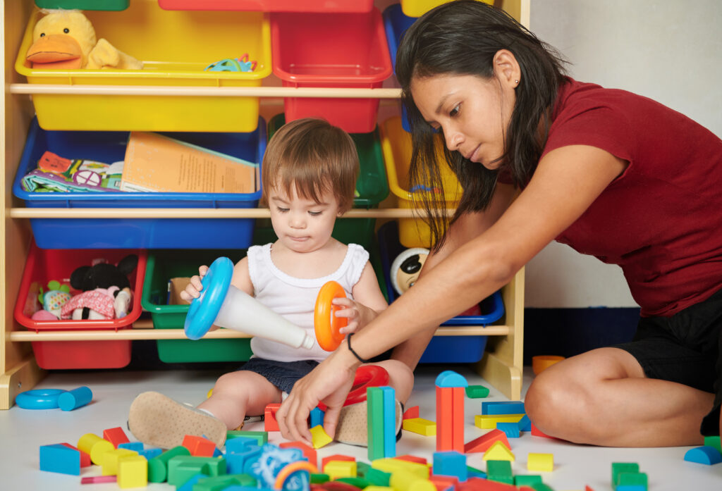 Teacher and small child playing.