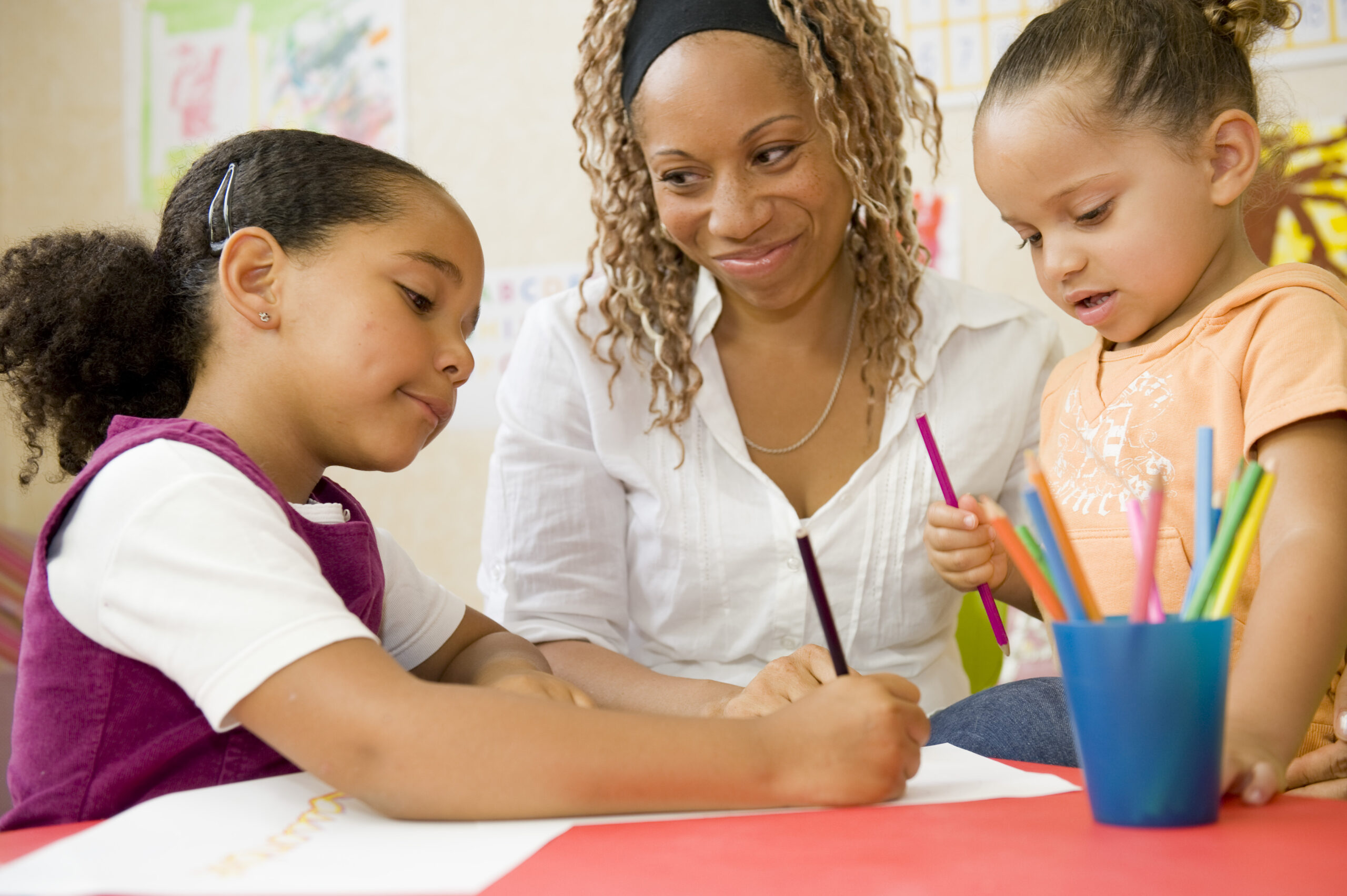 Teacher with two young students at a table