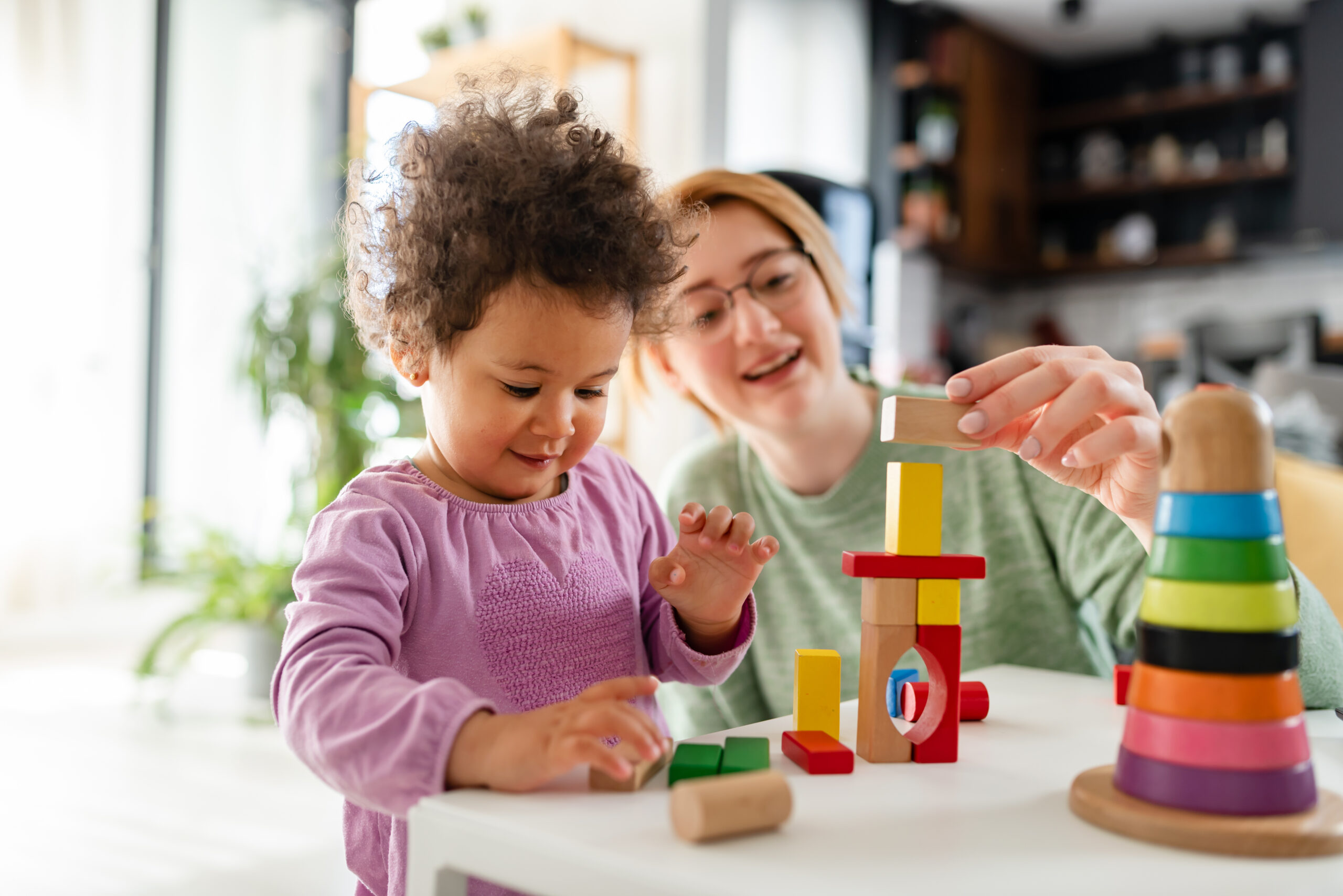 Teacher and child playing with blocks.