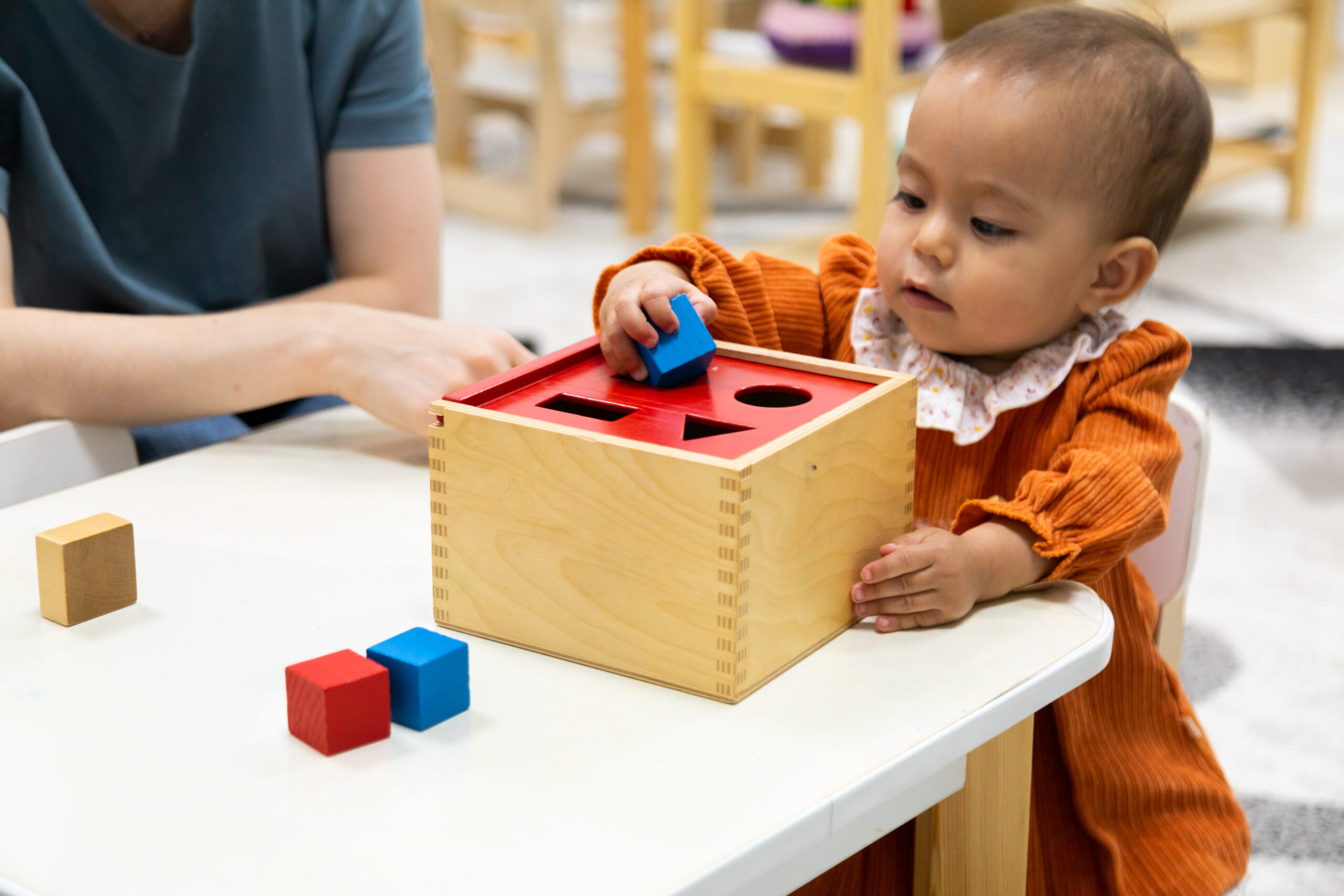 A small child playing with a shape toy.