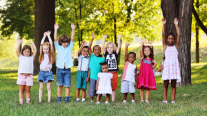 A large group of preschool children playing in the Park on the grass. The concept of friendship, childhood. Children's day, June 1