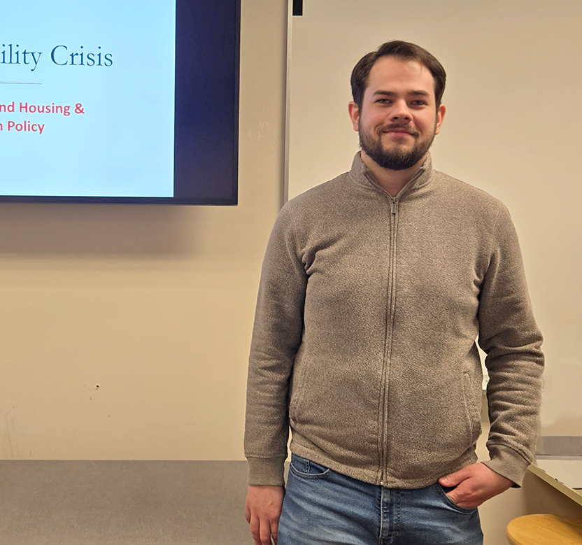 Adult man standing in front of presentation screen.